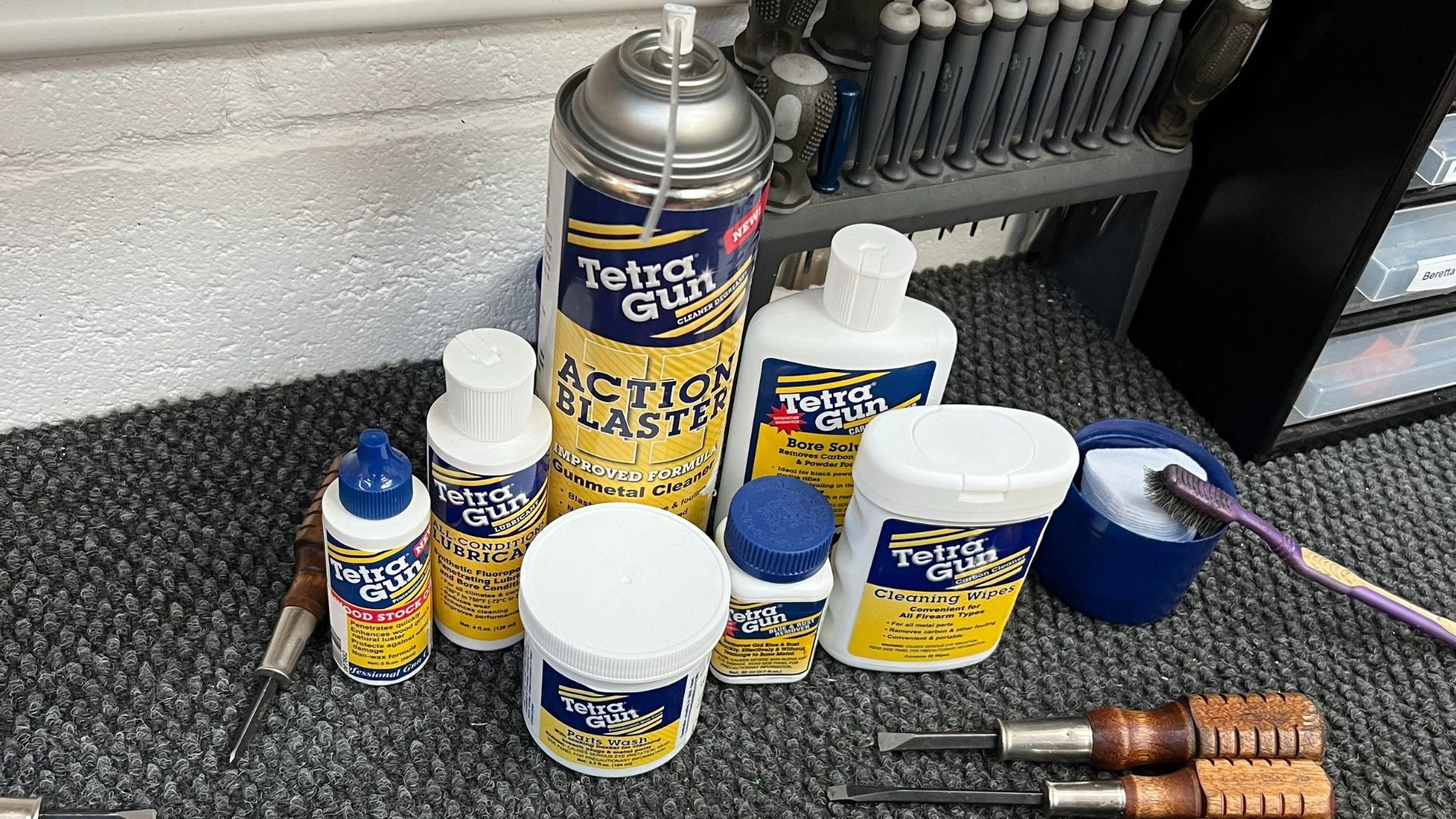 Collection of Tetra Gaulin products on a textured surface with tools in the background.